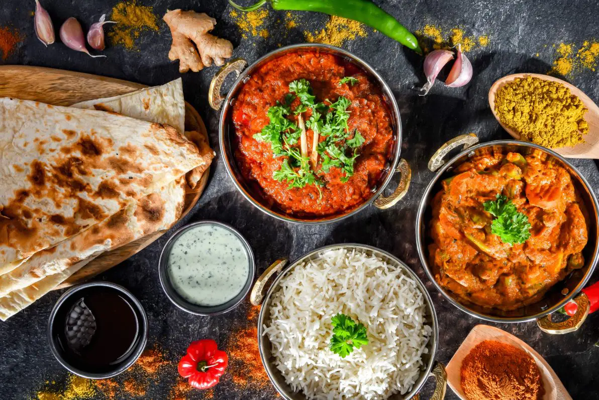 A table topped with bowls of food and some bread.