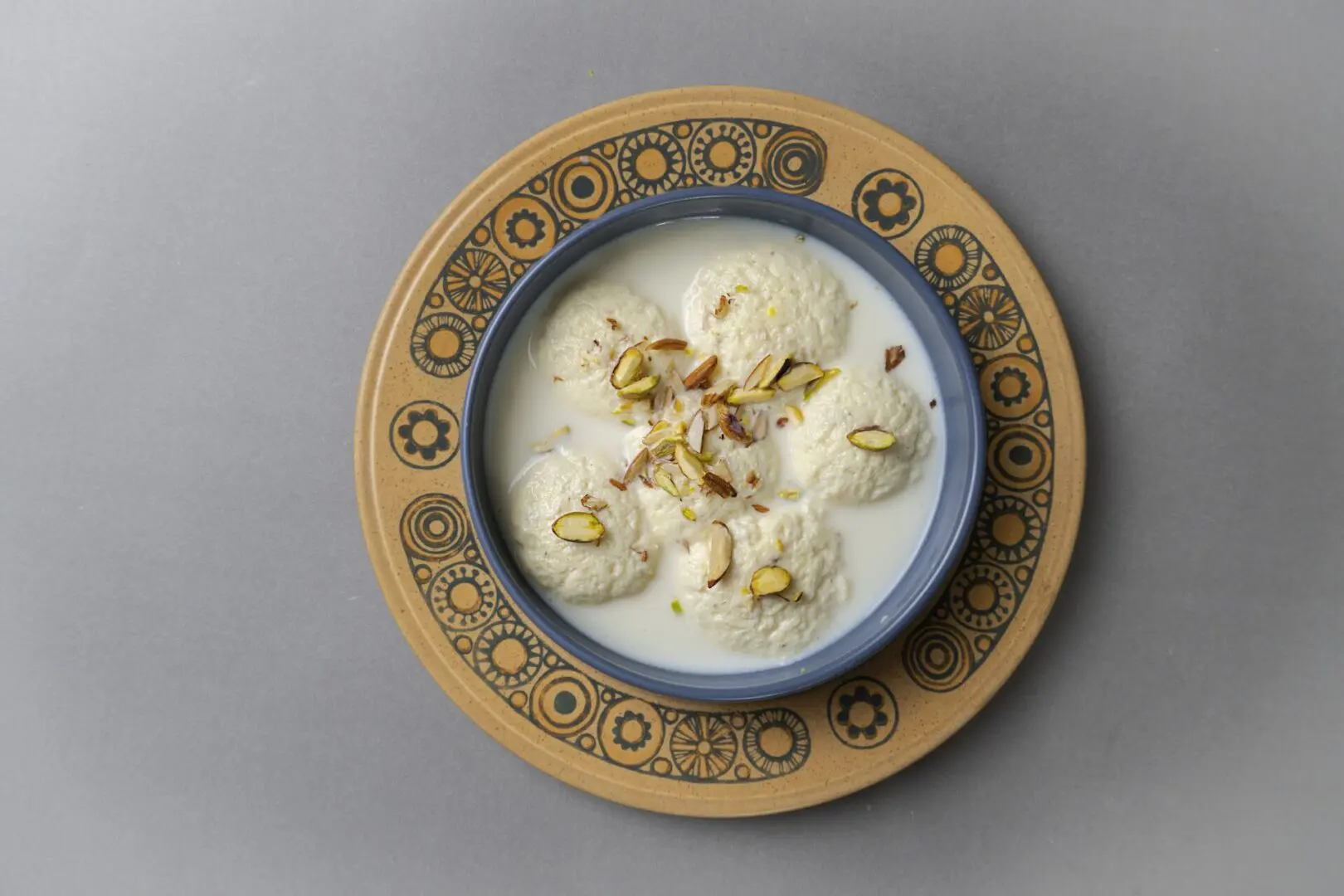 A bowl of food on top of a wooden plate.