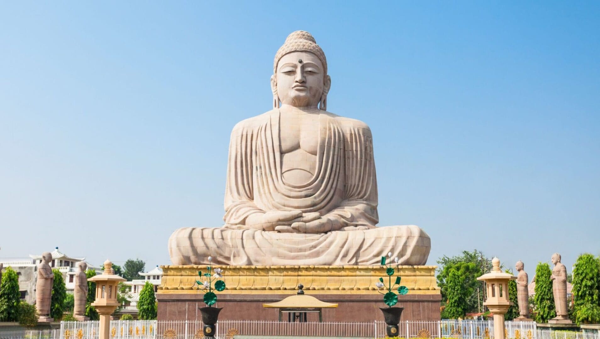 A large statue of buddha sitting on top of a hill.