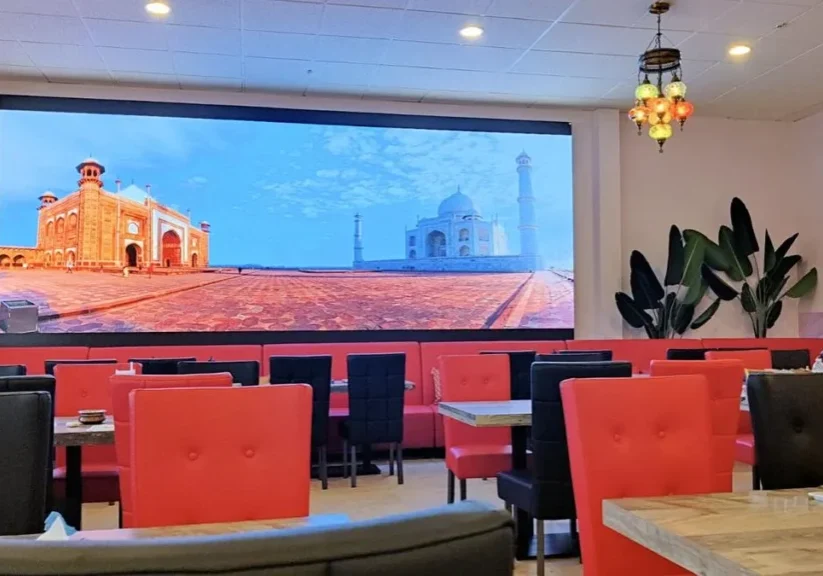 Indian restaurant interior with Taj Mahal image.