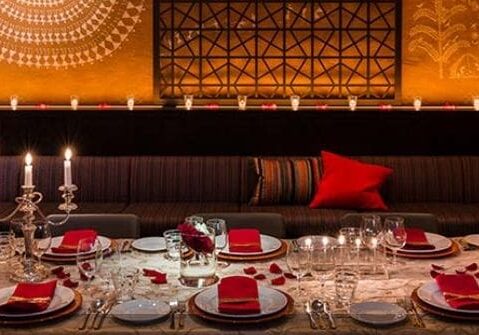 A table set with plates and glasses in front of a wall.